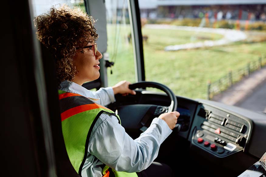 CDL licensed, DOT exam certified bus driver is shown in drivers seat