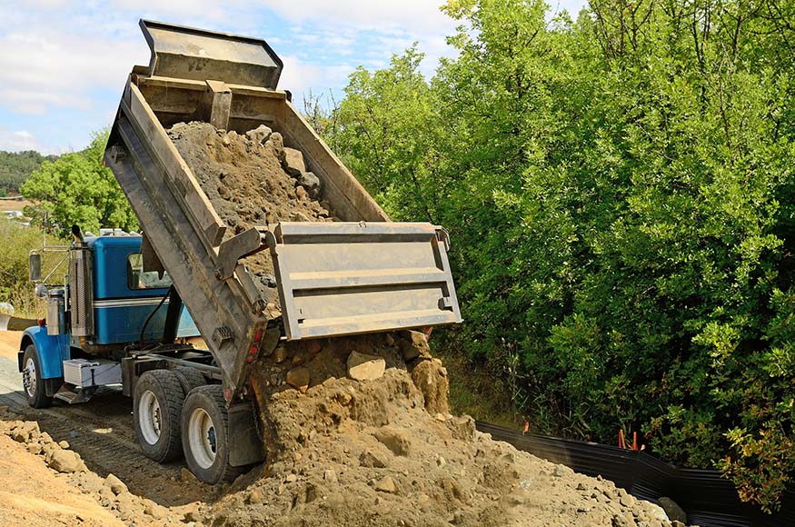 CDL licensed and DOT exam certified heavy equipment operator operating a dump truck.